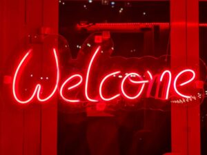 Red sign board of WELCOME by Hifive events